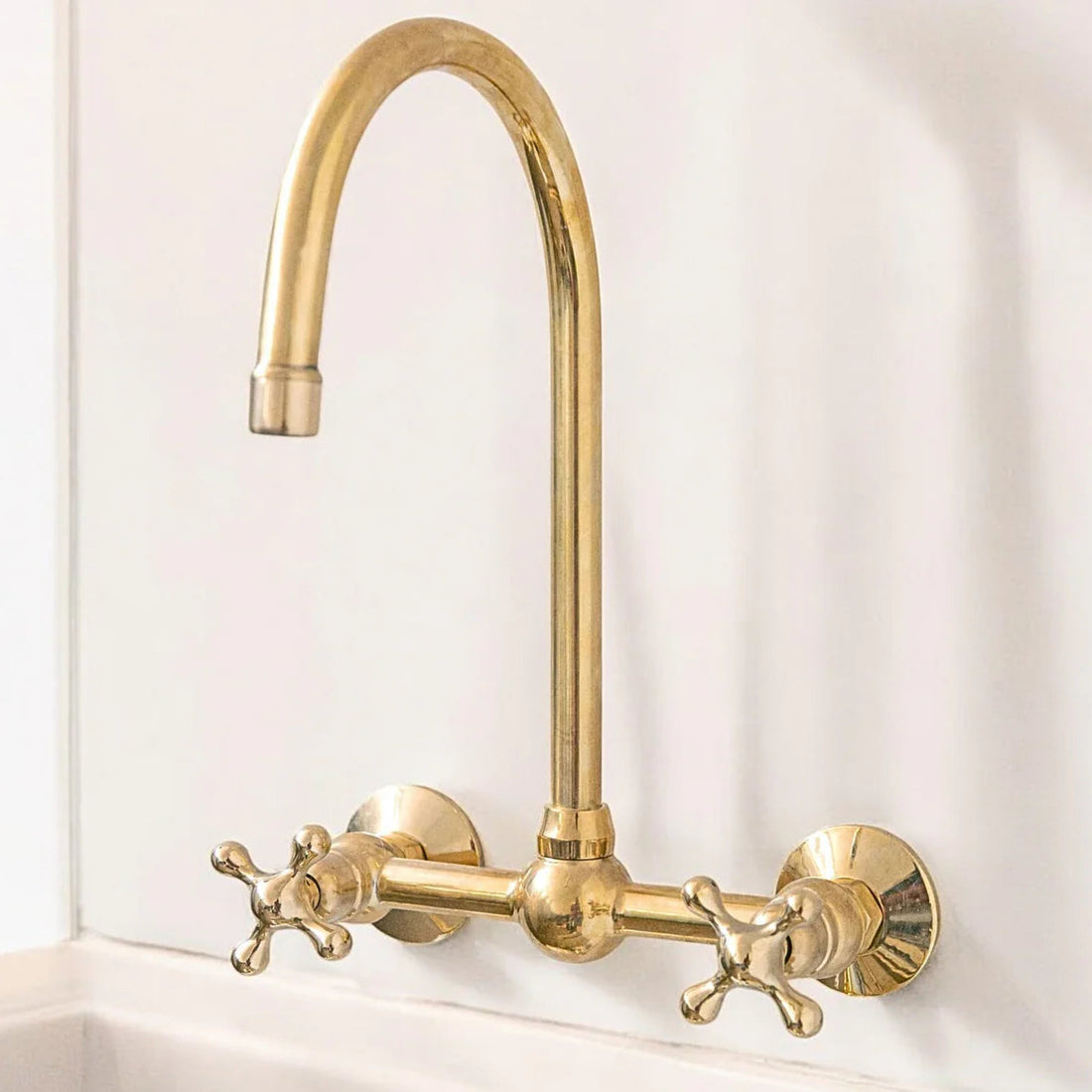 Unlacquered brass wall mount bridge faucet with gooseneck spout and ball center
