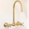 Unlacquered brass wall mount bridge faucet with gooseneck spout and ball center

