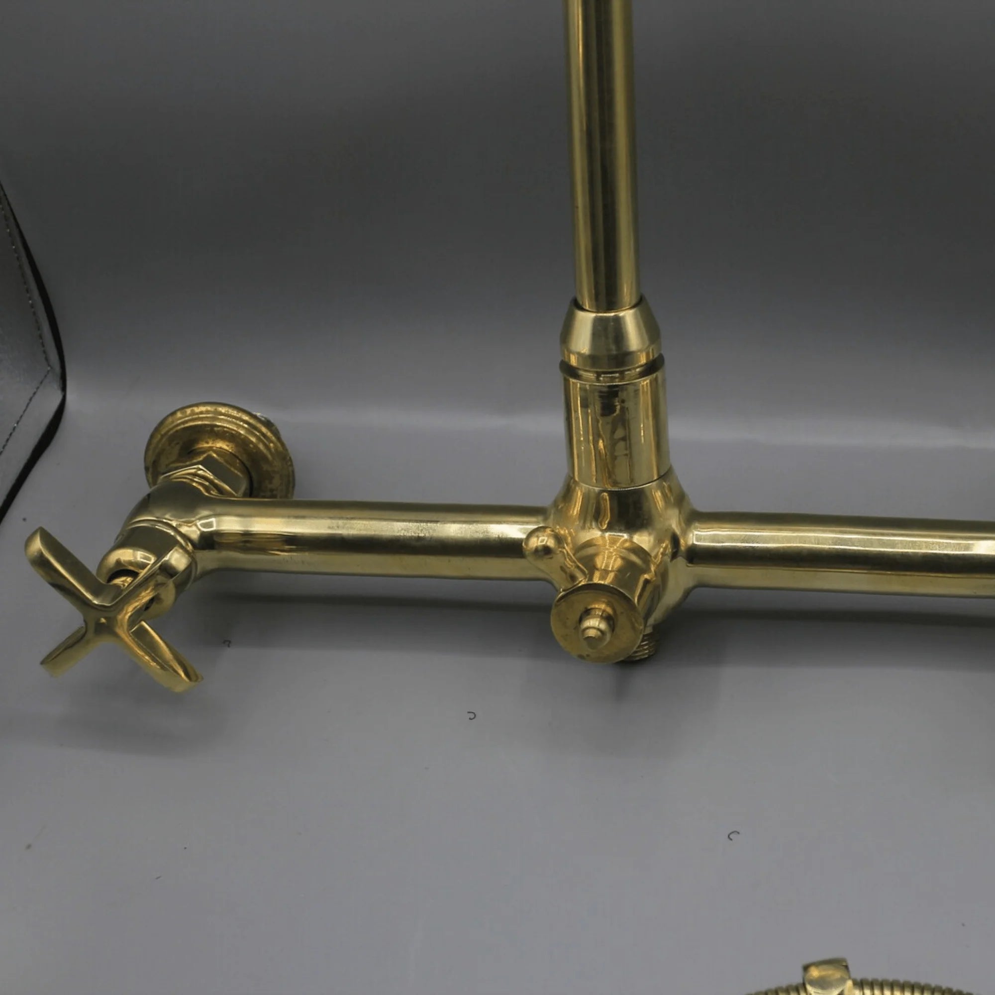 Unlacquered brass wall mount kitchen faucet with sprayer, 8 inch spread
